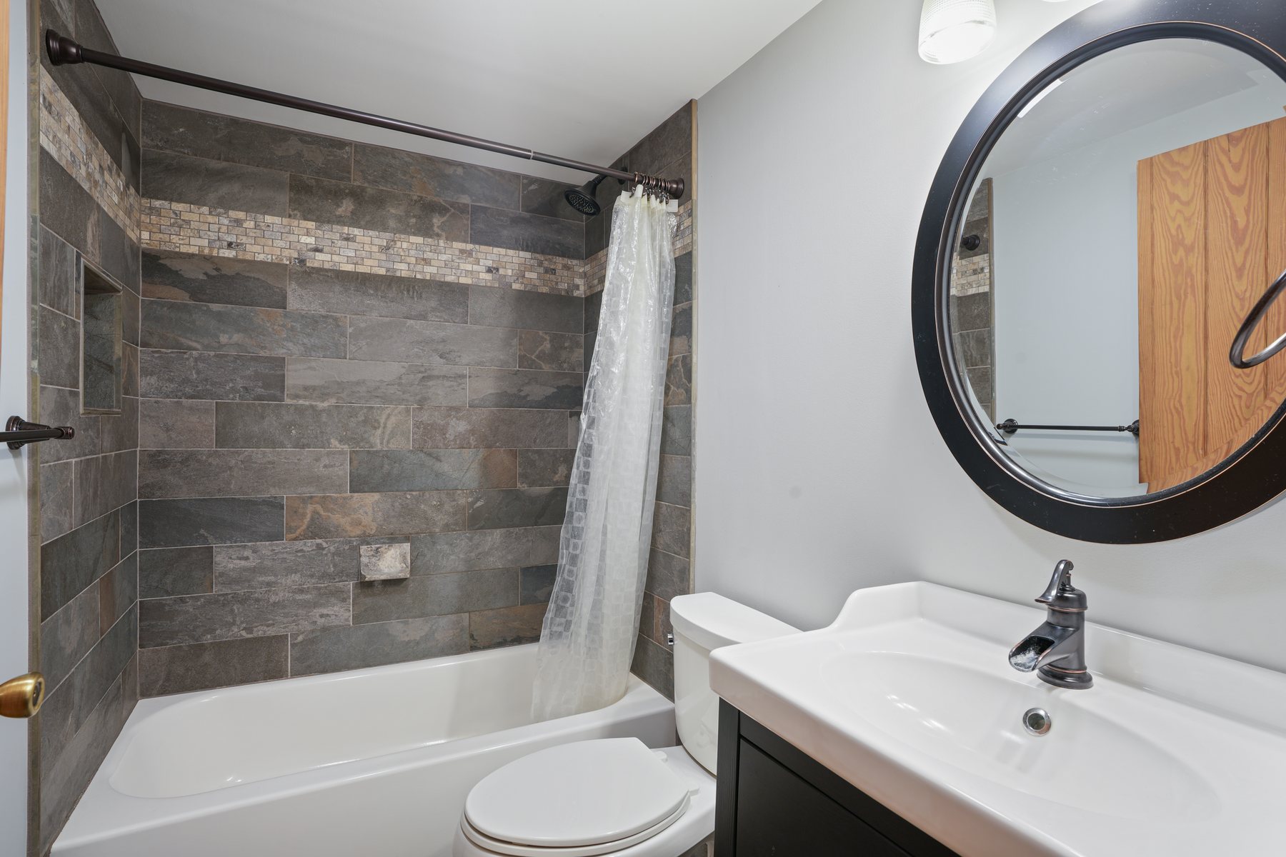 A renovated bath with a tiled shower surround